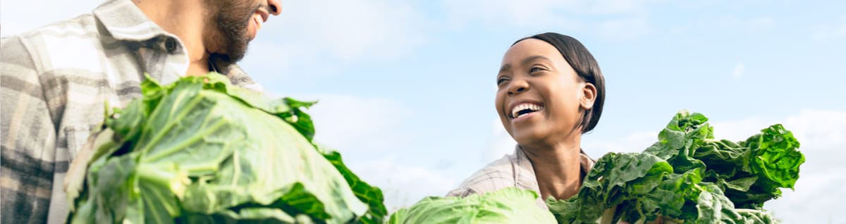Image of People Smiling Holding Vegetables