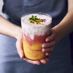 Girl holding colorful layered smoothie
