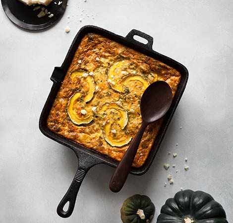 Frittata in a square cast iron skillet with a serving spoon