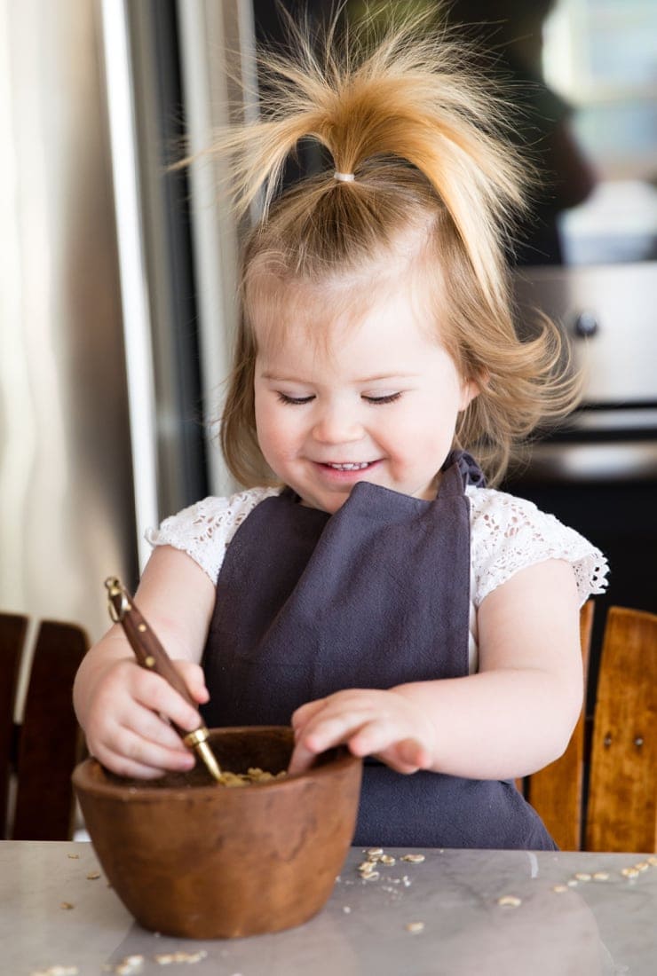 Young girl smiling and mixing ingredients