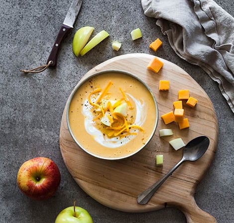 harvest cheddar soup on a platter with apples