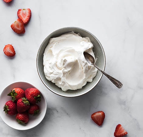 Whipped cream in a serving bowl with strawberries