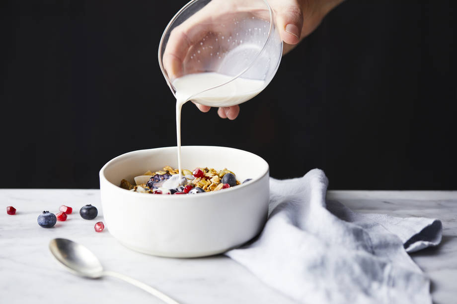 pouring almond milk over cereal