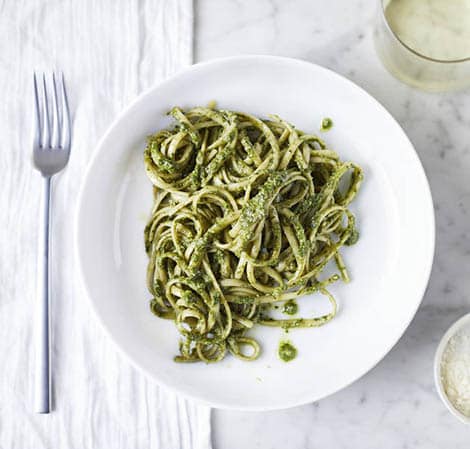 spaghetti with basil walnust pesto on a white plate