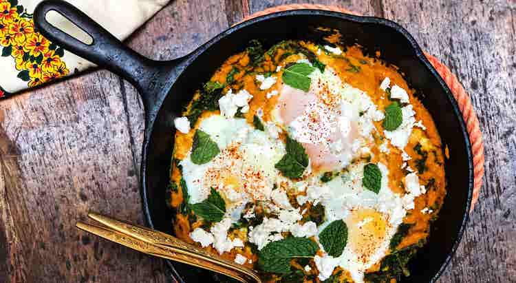 Baked eggs, carrot and harissa shakshuka, kale and feta
